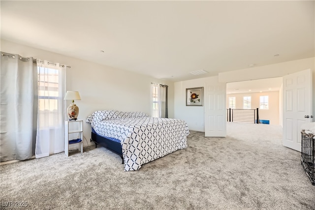 carpeted bedroom featuring multiple windows