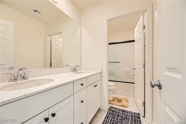 bathroom with toilet, double vanity, a sink, and visible vents