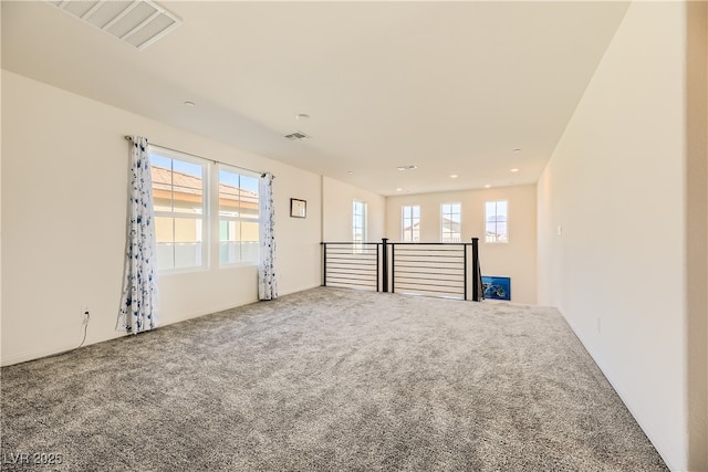 carpeted spare room featuring visible vents