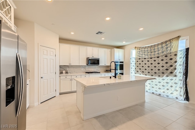 kitchen featuring recessed lighting, stainless steel appliances, visible vents, white cabinets, and decorative backsplash