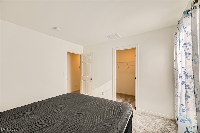 bedroom with light carpet, visible vents, baseboards, a spacious closet, and a closet