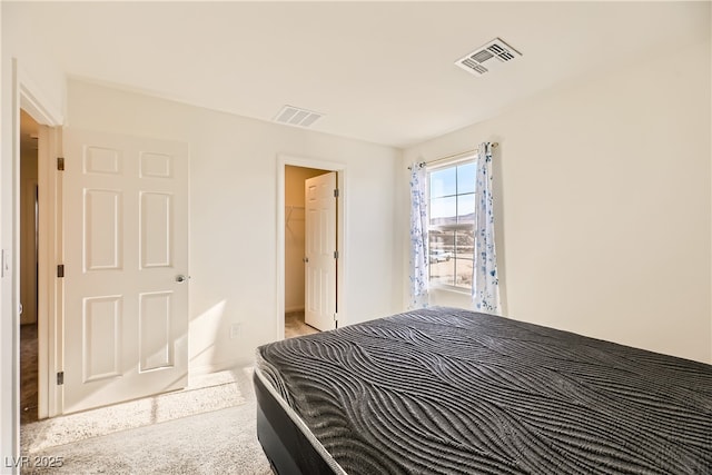 bedroom with a walk in closet and visible vents