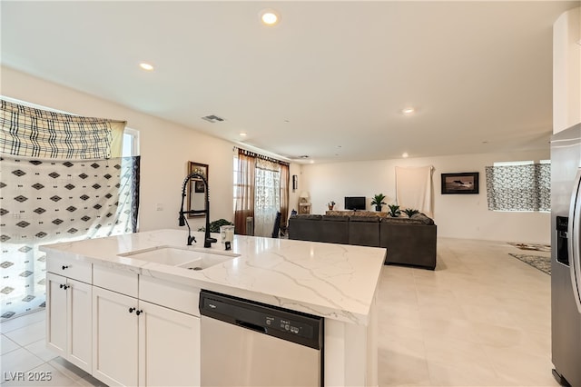 kitchen with recessed lighting, appliances with stainless steel finishes, open floor plan, white cabinetry, and a sink