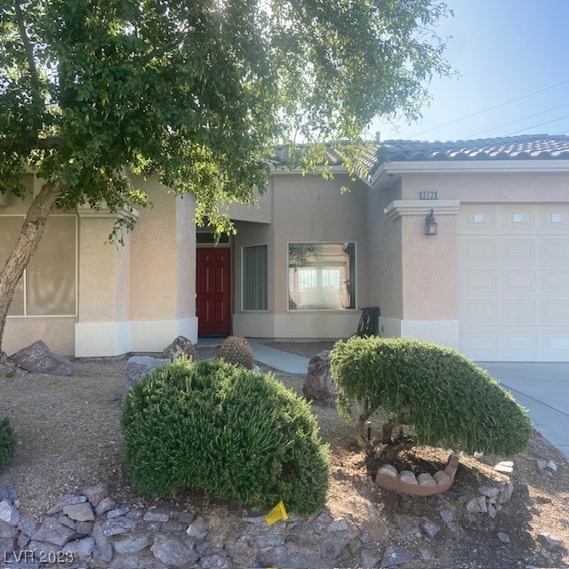 entrance to property with stucco siding and an attached garage