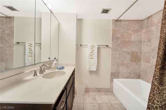 bathroom with tile patterned flooring, tiled shower / bath combo, and vanity