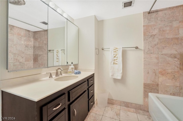 bathroom with vanity, tile patterned flooring, and tiled shower / bath