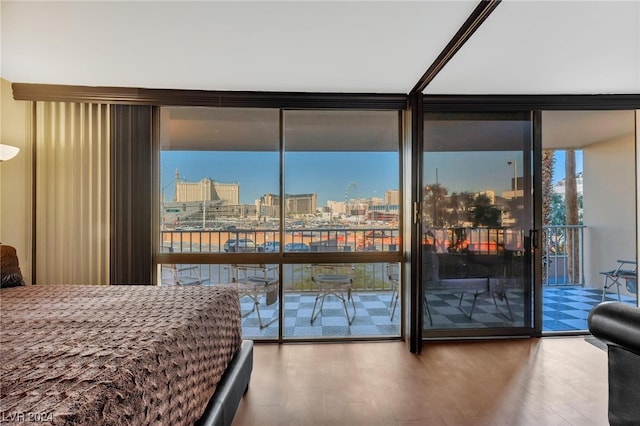 bedroom with access to exterior, hardwood / wood-style flooring, and floor to ceiling windows