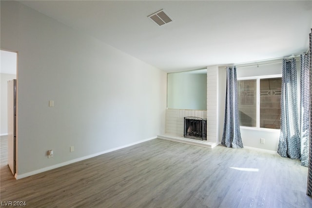 unfurnished living room featuring a fireplace and hardwood / wood-style floors