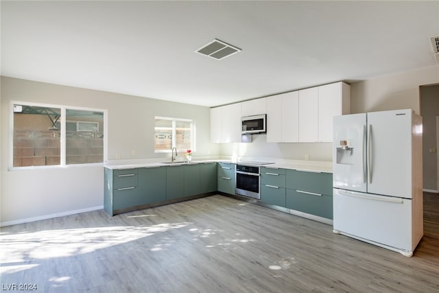 kitchen featuring light hardwood / wood-style floors, appliances with stainless steel finishes, white cabinets, and sink