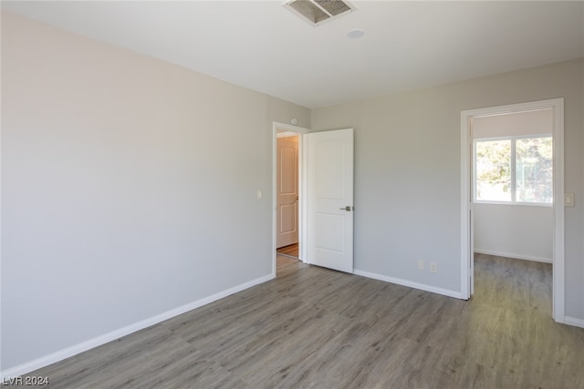 unfurnished bedroom with hardwood / wood-style floors and a spacious closet