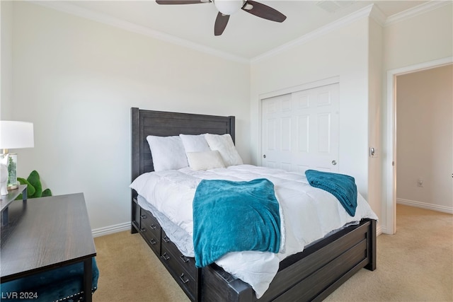 bedroom featuring ceiling fan, light colored carpet, a closet, and crown molding