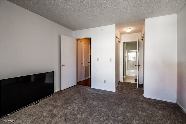 unfurnished bedroom with dark carpet and a textured ceiling