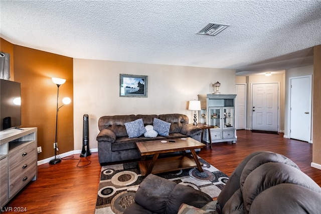 living room with dark hardwood / wood-style floors and a textured ceiling