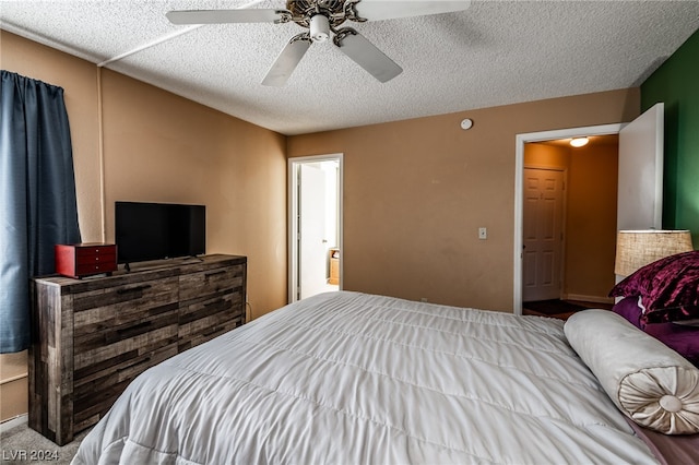 bedroom with ceiling fan and a textured ceiling