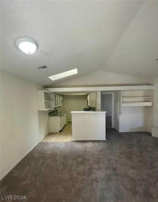 basement featuring light carpet and a textured ceiling