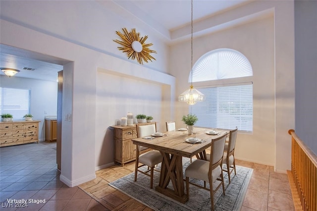 dining room featuring a notable chandelier, light tile patterned floors, and a healthy amount of sunlight