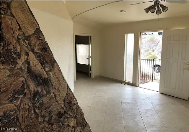 empty room featuring light tile flooring and ceiling fan