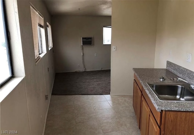 kitchen with light tile flooring, a wall mounted air conditioner, and sink