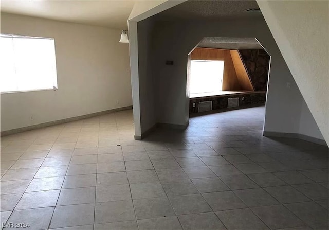 additional living space featuring dark tile flooring