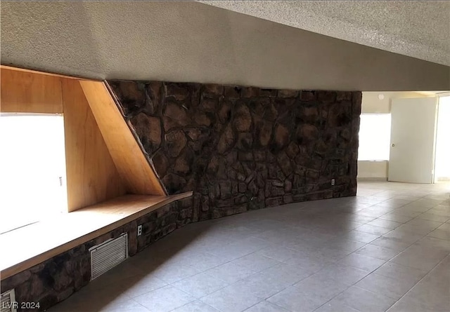 interior space with light tile floors and a textured ceiling