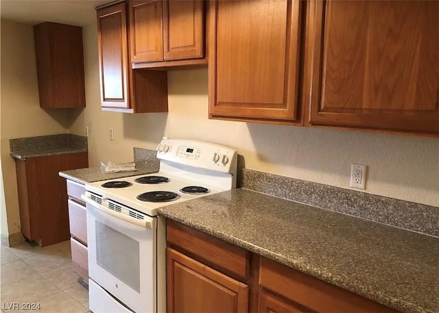 kitchen featuring light tile floors and electric range