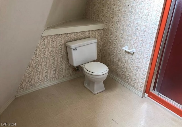 bathroom featuring toilet and tile floors