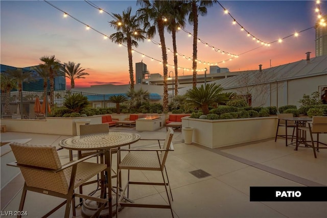 patio terrace at dusk with an outdoor living space with a fire pit