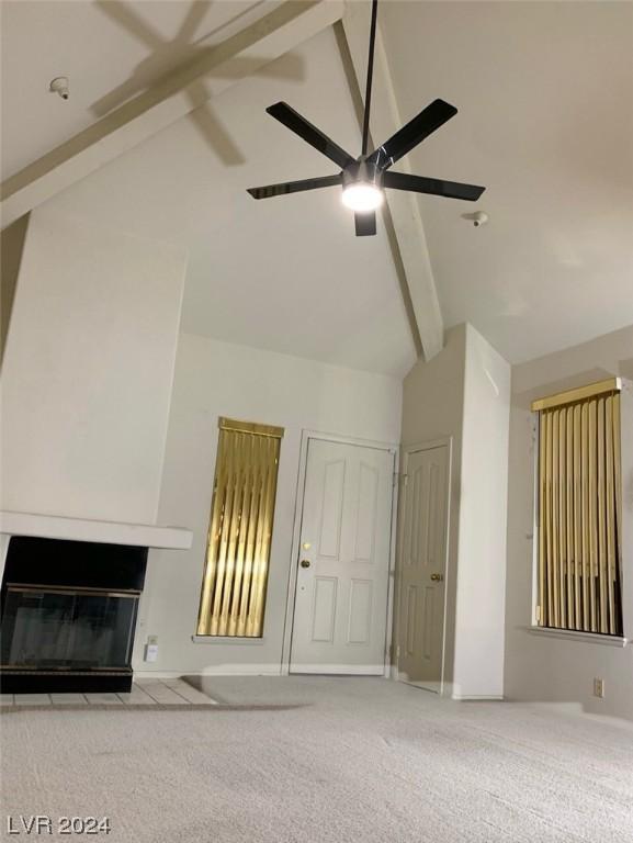 interior space with beam ceiling, ceiling fan, and light colored carpet