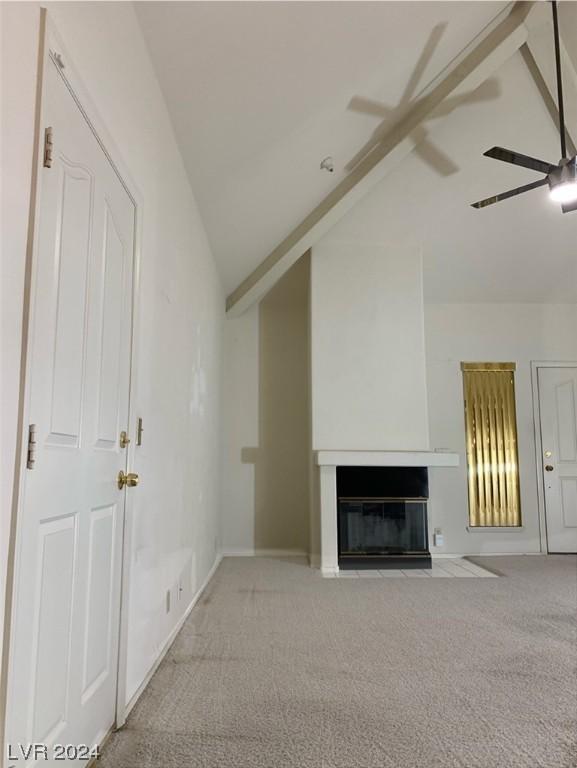 unfurnished living room with light colored carpet, vaulted ceiling, and ceiling fan