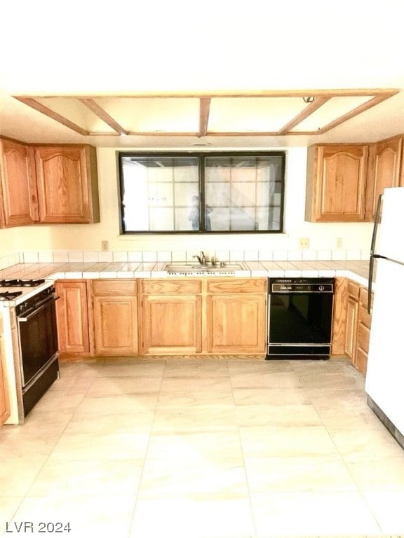 kitchen with white appliances, tile countertops, sink, and light tile flooring