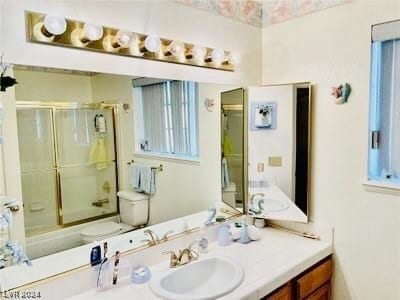 full bathroom featuring toilet, shower / bath combination with glass door, and oversized vanity