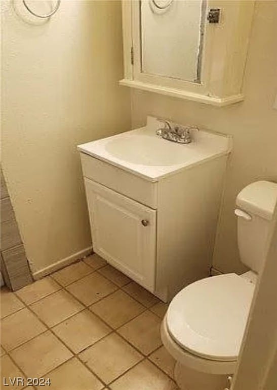 bathroom featuring tile floors, toilet, and vanity