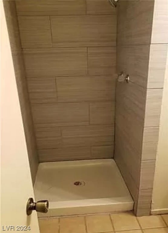 bathroom featuring tile flooring and tiled shower