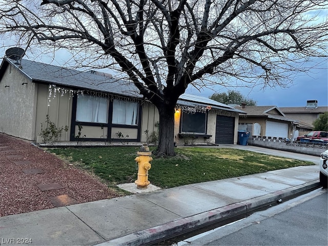 view of front of home featuring a front lawn and a garage