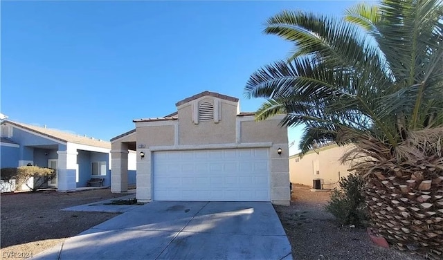 view of front facade with a garage and central AC