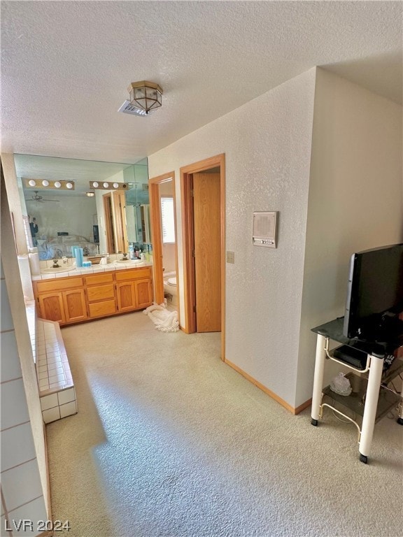 bathroom with a textured ceiling, vanity, and toilet