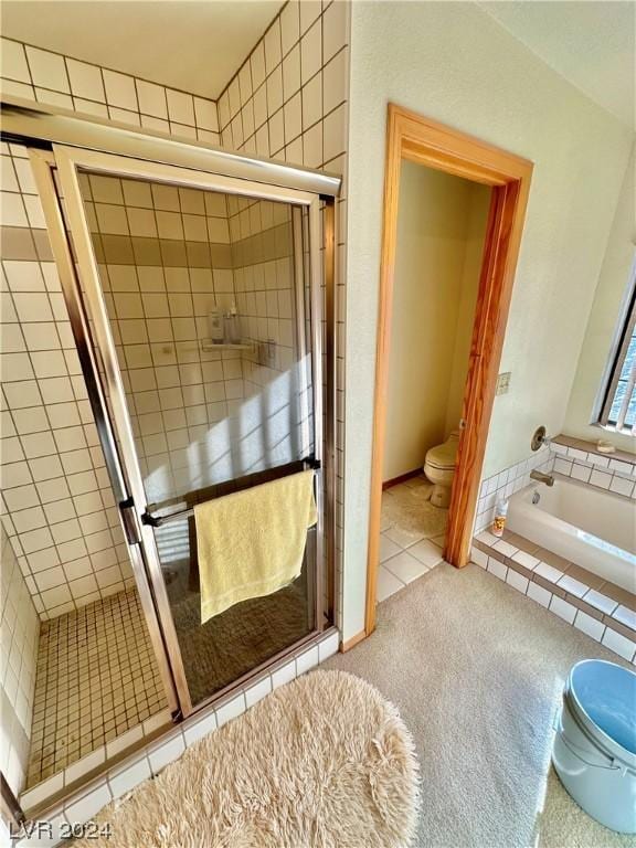 bathroom featuring tile patterned flooring, a shower stall, toilet, and tiled tub