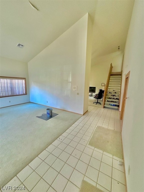 empty room with light colored carpet and vaulted ceiling