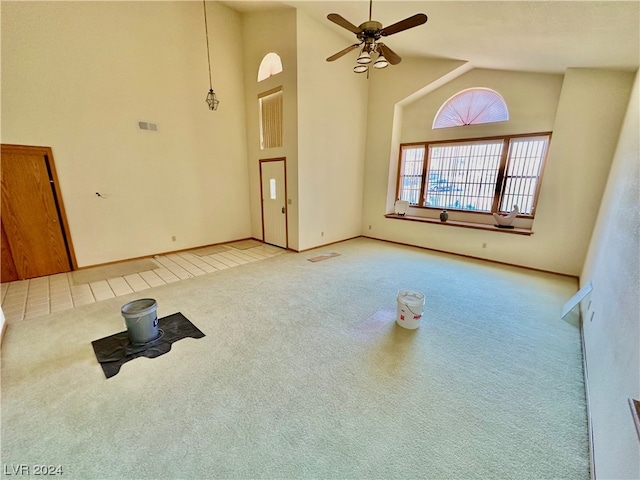 unfurnished living room featuring ceiling fan, light colored carpet, and high vaulted ceiling