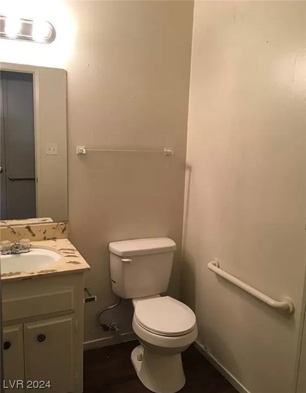 bathroom with hardwood / wood-style floors, toilet, and vanity