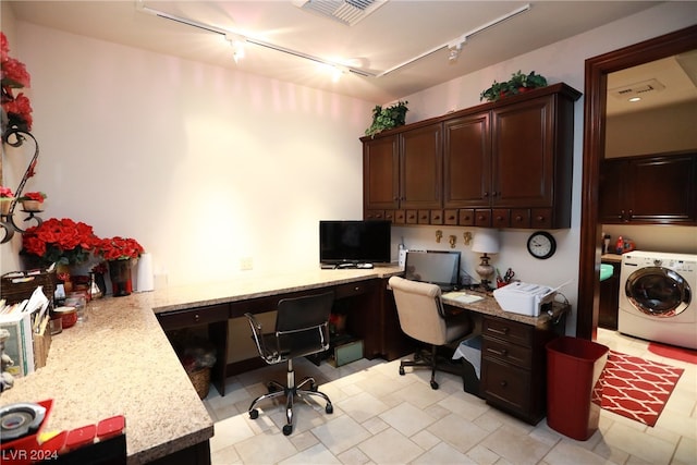 office space featuring light tile floors, track lighting, washer / clothes dryer, and built in desk