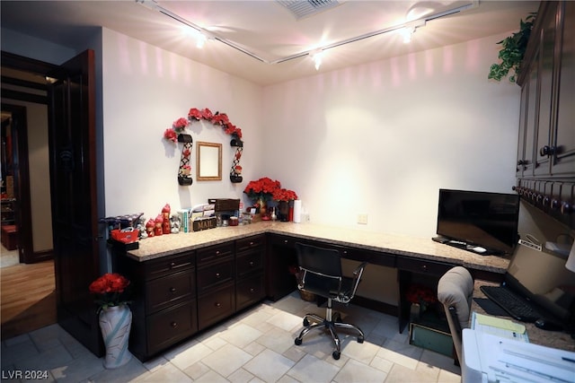 tiled office space with track lighting and built in desk