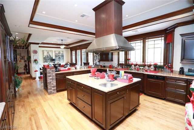 kitchen with a center island with sink, ceiling fan, light stone countertops, and light hardwood / wood-style flooring