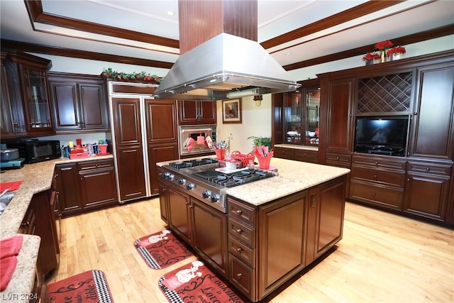 kitchen featuring stainless steel gas cooktop, a kitchen island, light stone counters, light hardwood / wood-style floors, and island range hood