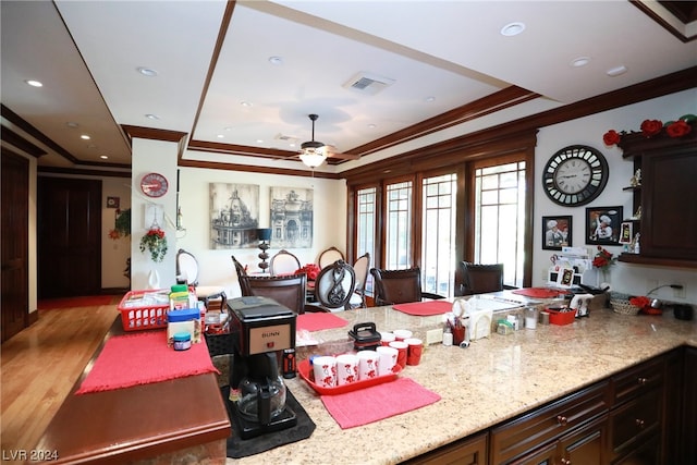 kitchen with dark hardwood / wood-style floors, dark brown cabinets, ceiling fan, and light stone counters