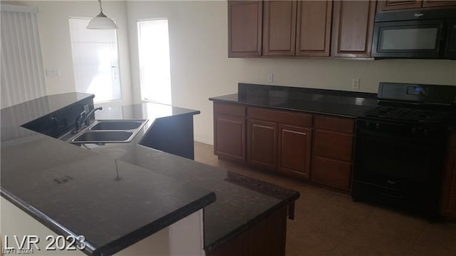 kitchen featuring dark brown cabinetry, dark tile floors, black appliances, pendant lighting, and sink