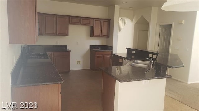 kitchen with a kitchen island, light tile flooring, and sink