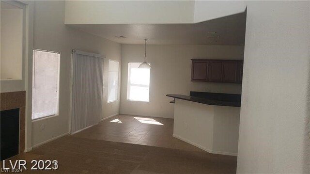 kitchen with dark brown cabinets, decorative light fixtures, and tile flooring