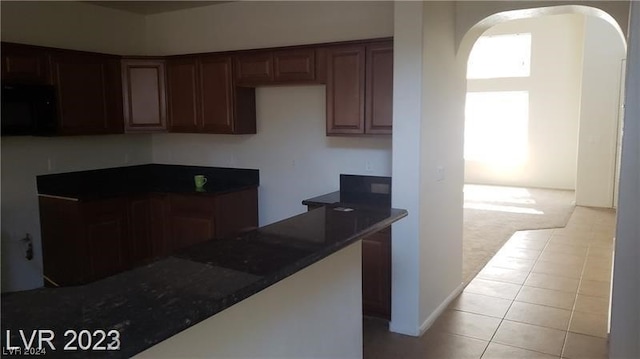 kitchen with light tile floors and dark brown cabinetry