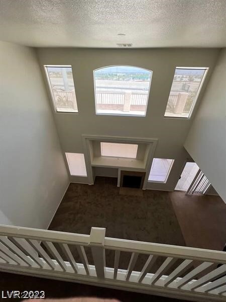 staircase featuring carpet flooring and a textured ceiling